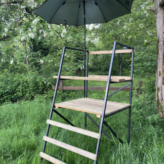 Porte-parapluie installé sur mirador en bois, avec fixation sécurisée et parapluie de chasse en place